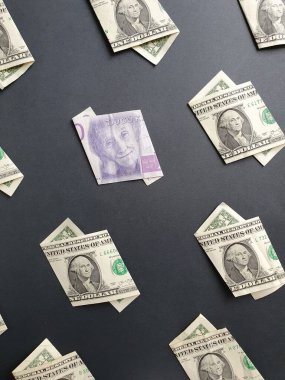 Bir dolarlık Amerikan banknotları ve siyah arka planda 20 kronluk İsveç banknotu.
