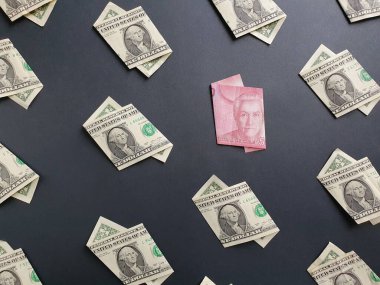 Bir dolarlık Amerikan banknotları ve siyah arka planda 5000 pezoluk Şili banknotu.