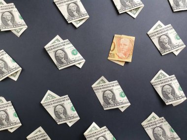 Siyah arka planda bir dolarlık Amerikan banknotları ve 20 reais 'lik Brezilya banknotları.