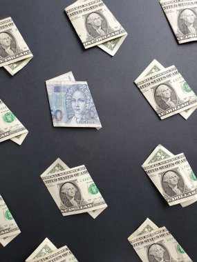 Siyah arka planda bir dolarlık Amerikan banknotları ve 50 kuna değerinde Hırvat banknotları var.