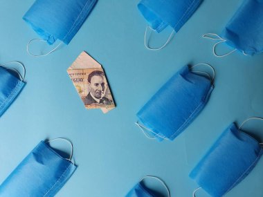 Mavi arka planda 100 peso ve maskeli uruguay banknotu