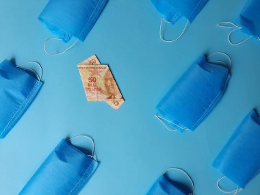 Mavi arka planda 50 lira ve maskeli Türk banknotu