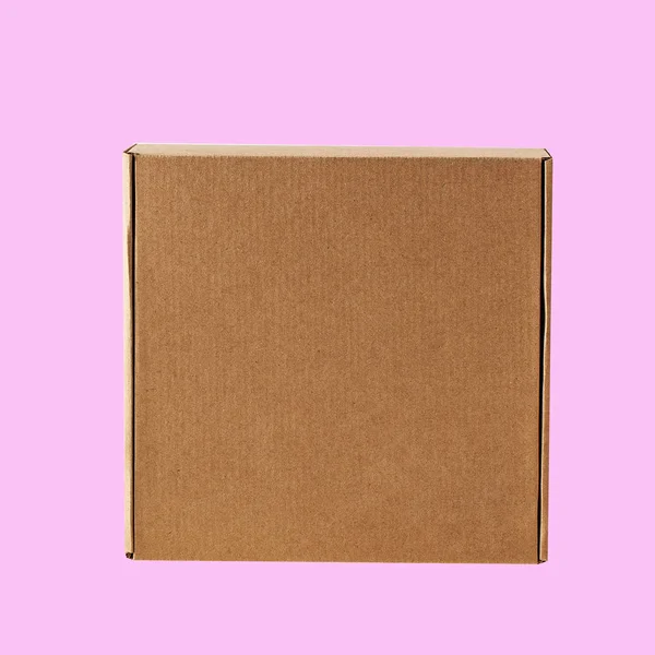 Kraft karton kwadratowy zamknięte pole widok z góry. Pudełko jest wyryte na różowym tle.. — Zdjęcie stockowe