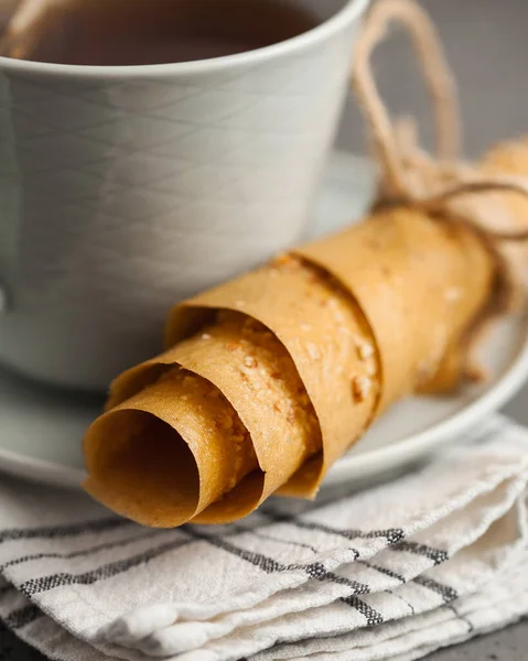 Thin homemade Apple pastille close-up. A healthy snack on a saucer next to a mug of tea.