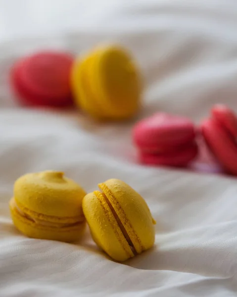 Beyaz arka planda renkli kurabiyeler. Beyaz yatakta sarı ve kırmızı badem kurabiyeleri.. — Stok fotoğraf
