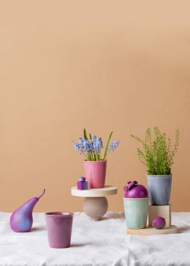 Beyaz masa örtüsünün üzerinde çiçekler, parlak meyveler ve kupalar olan modern bir hayat. Dikey fotoğraf biçimi 5 x 7. Armut boyası. Tebrik kartı.