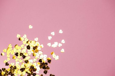 Pembe arka planda altın kalp şeklinde bir sürü pul var. Metin girişi için bol alanı olan kart, aşk teması. Yatay fotoğraf.