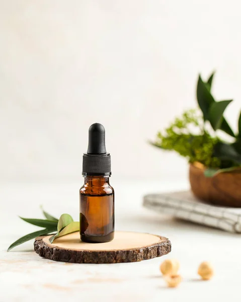 Cilt bakımı. Ahşap tezgahta nemlendirici serum, arka planda yeşil yapraklar. Metin için bir yer var.