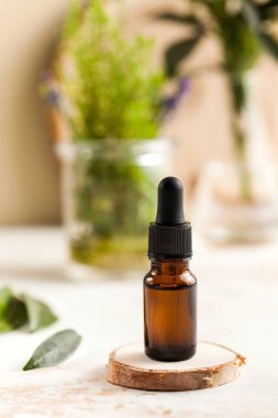 Cilt bakımı. Ağaç tezgahta, yeşil yaprağın yanında yüz ve vücut için nemlendirici serum veya yağ, arka planda bitkiler.