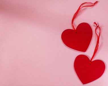 14 Şubat Sevgililer Günü 'nde, bir aşk ilanı için bayram kartı. Pembe arka planda iki kırmızı kalp.