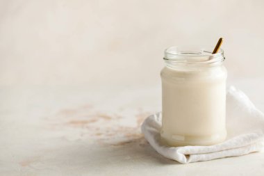 Sağlıklı kahvaltı. Termostatik mayalanmış süt ürünü yoğurdu cam bir kavanozda, solunda yazı için yer var..