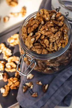  Cam kavanozda bir avuç ceviz. Marketler için yiyecek fotoğrafı, sağlıklı atıştırmalıklar, vejetaryen yiyecekler..