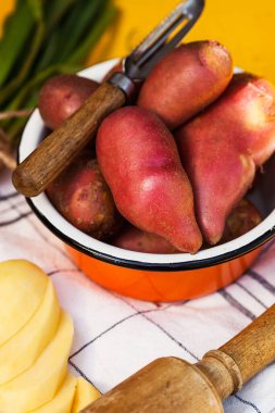 Kırmızı patatesler derin bir kasede, doğranmış patateslerin yanında. Bahçıvanlar, dükkanlar ve gıda pazarları için yiyecek fotoğrafı.