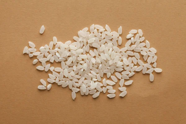 White handful rice on a brown background. for vegetarians, grocers, health food stores, rice packaging mockup.