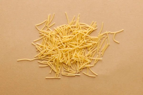 Italian short thin vermicelli on a brown background. Close-up, layout for a grocery store, menu, recipes, pasta packs.
