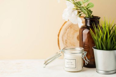 Ev dekorasyonu mumu, vazo, tencerede yeşil bitki ve metin için yer var. Yatay fotoğraf, yaşam tarzı konsepti