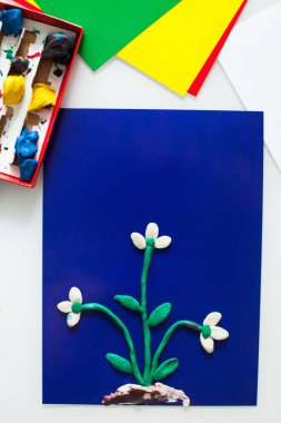step-by-step instructions for children's crafts made of plasticine. Making a snowdrop step 5. Color paper close-up with space for text. clipart