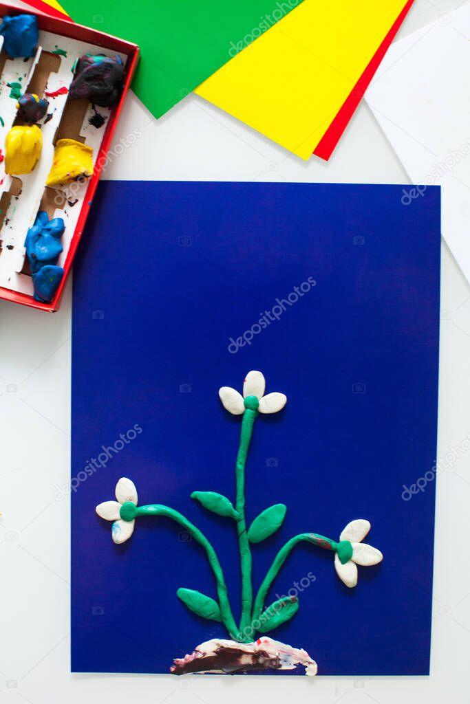 step-by-step instructions for children's crafts made of plasticine. Making a snowdrop step 5. Color paper close-up with space for text.