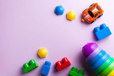  Çocuklar düzüşüyor. Çocuk tasarımcısı, arabalar, renkli arka planda piramit. Geliştirme ve ebeveynlik kavramı. Tasarımcı, ayırıcı, yaratıcı. Çocuğun boş vakitleri ve hobileri. Boşluğu kopyala.