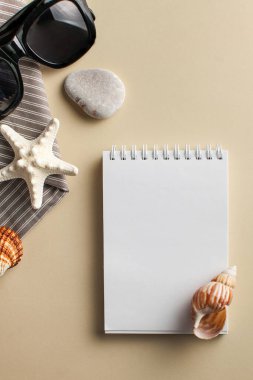  Tropikal arka plan. Beyaz defter, deniz kabuğu, güneş gözlüğü olan düz bir yatak. Seyahat kavramı, deniz tatili..