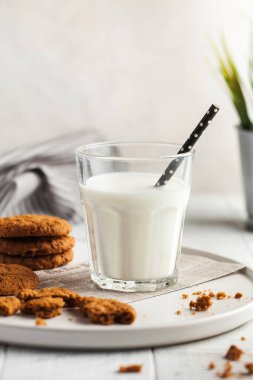  Bir bardak süt, kurabiye, arka planda bir sürahi süt. Süt konsepti, süt ürünleri kullanımı, tarım ürünleri. Uzayı kopyala Dikey yemek fotoğrafı.