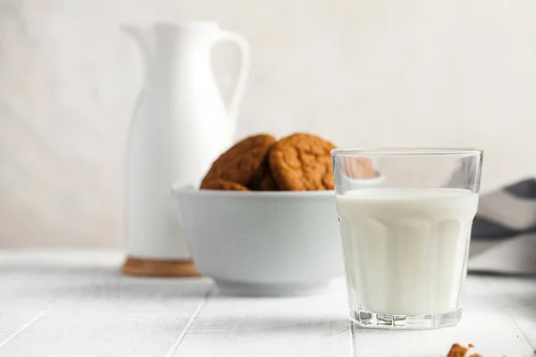 Glass of milk, milk jug, cookies in a bowl on a light background. The concept of dairy products, farm products, the use of milk, milk day.