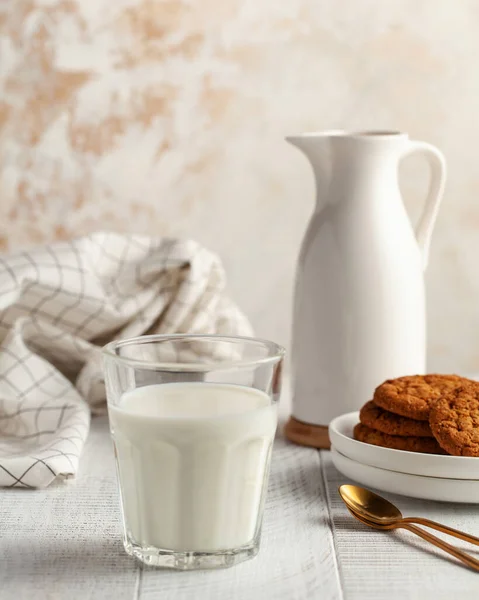 Glass of milk, jug, cookies. The concept of dairy products, the use of milk, farm products. Copy space. Vertical food photo.