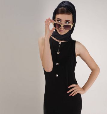 retro tarzı başörtüsü ve ışık arka plan üzerinde güneş gözlüğü ile güzel kadın