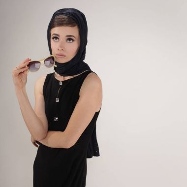 retro tarzı başörtüsü ve ışık arka plan üzerinde güneş gözlüğü ile güzel kadın