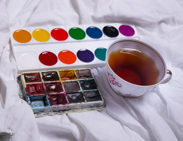 Вид зверху на фарбу, чистий аркуш паперу, чашка чаю, маркери . — стокове фото
