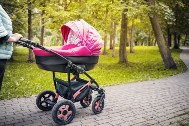Bir bebek arabası elini kolunu sallaya parkta dönüyor