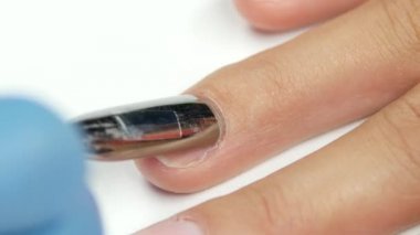 Manikürcü çivi bir spatula ile çalışır ve cuticles geri iter. Yakın çekim