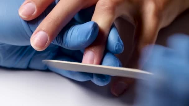 Manicure maakt de vorm van een nagel van een client met een nagelvijl. Close-up — Stockvideo