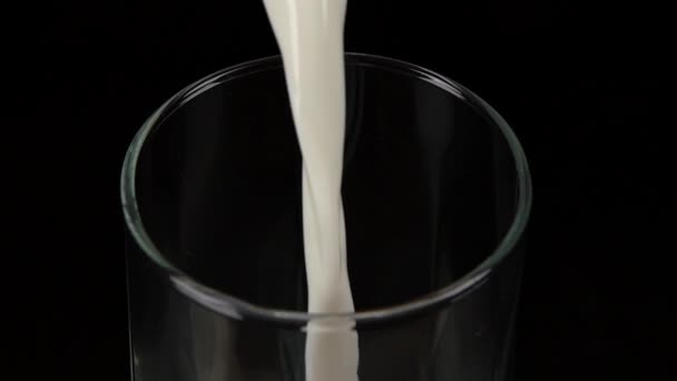 Versare il latte nel bicchiere. Nero. Al rallentatore. Da vicino. — Video Stock