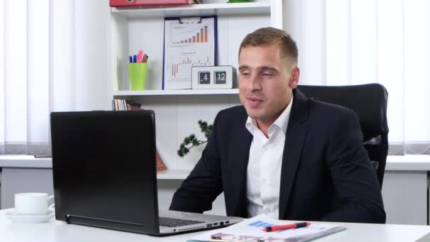 Hombre en traje hablando en una cámara web y sonriendo — Vídeo de stock