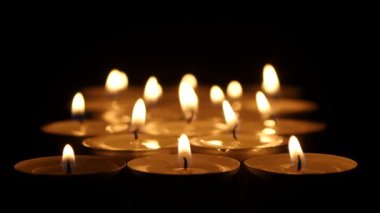 Grup siyah arka plan üzerine mumlar yanan. Yakın çekim