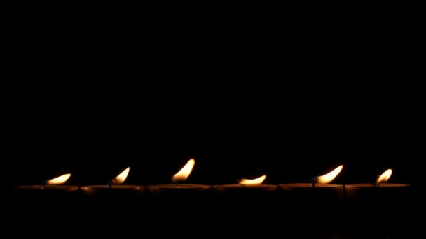 Six petites bougies dans le noir. Gros plan 