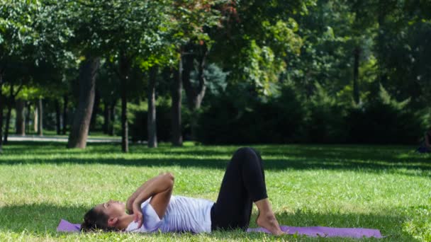 Žena cvičí jógu v parku — Stock video