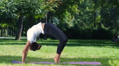 Sportif kız parkta yoga yapıyor