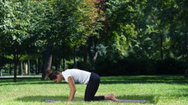 Kadın pratik yoga, dizlerinin üzerinde poz