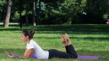 Kız yoga yaparken bir selfie yapar. Park güneşli bir günde