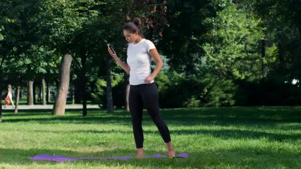 Chica hace un selfie haciendo yoga en el parque — Vídeos de Stock