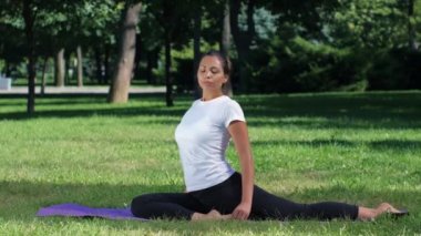 Kız yoga yaparken bir selfie yapar. Park güneşli bir günde