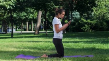 Kız selfie yoga konumda akıllı telefon ile yapıyor
