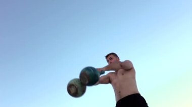 Adam aynı anda iki halter yükseltmek. Ağır çekim