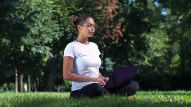 Estudiante trabajando en portátil en el parque — Vídeos de Stock