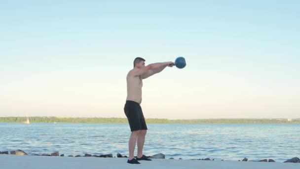 Homem atlético levanta halteres pesados. Movimento lento — Vídeo de Stock