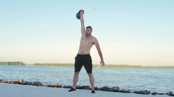 Sportsman plockar upp en hantel med ena handen. Slow motion — Stockvideo