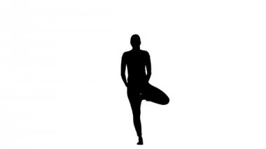 Kız bir ağaç poz gösterir. Siluet