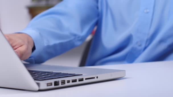 Compras en línea. Laptop. Hombre escribiendo en un ordenador portátil mientras sostiene una tarjeta de crédito . — Vídeos de Stock